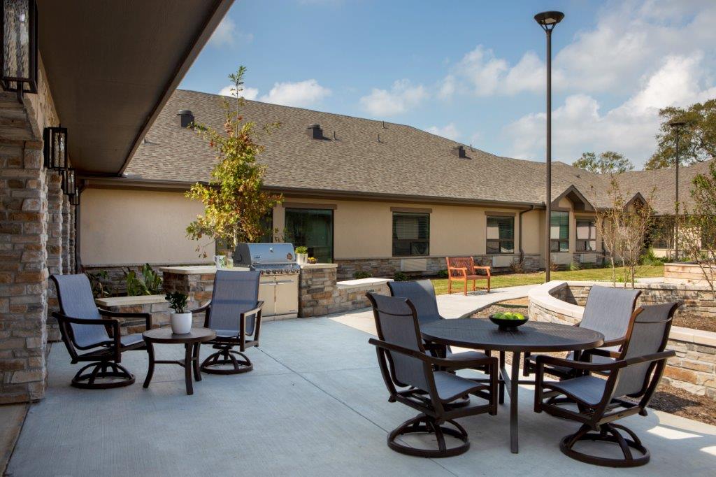 An outdoor patio with a grilling area and seating at The Shores at Clear Lake, a trusted choice for senior living.