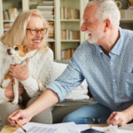 April 25 Events Page Image - The Shores at Clear Lake Elderly man and woman smiling and holding small dog